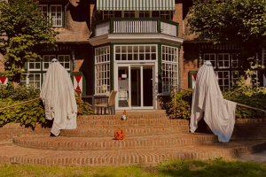 Twee medewerkers van Visio zijn verkleed als spook voor de Halloween wervingscampagne. Zij staan buiten op het bordes voor visio locatie Breda.