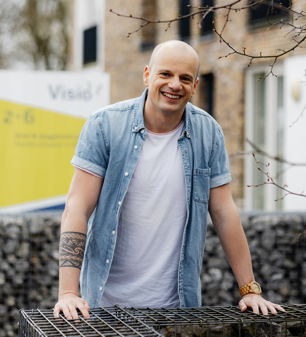 Begeleider Andy staat buiten bij Visio Locatie De Blauwe kamer, Breda