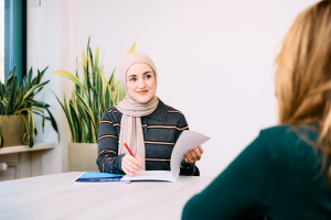 Een gedragskundige maakt notities tijdens een gesprek met een cliënt.